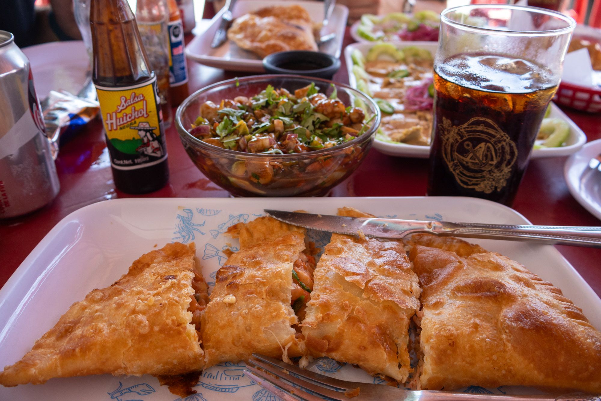 Table set with seafood empanadas and seafood dishes.