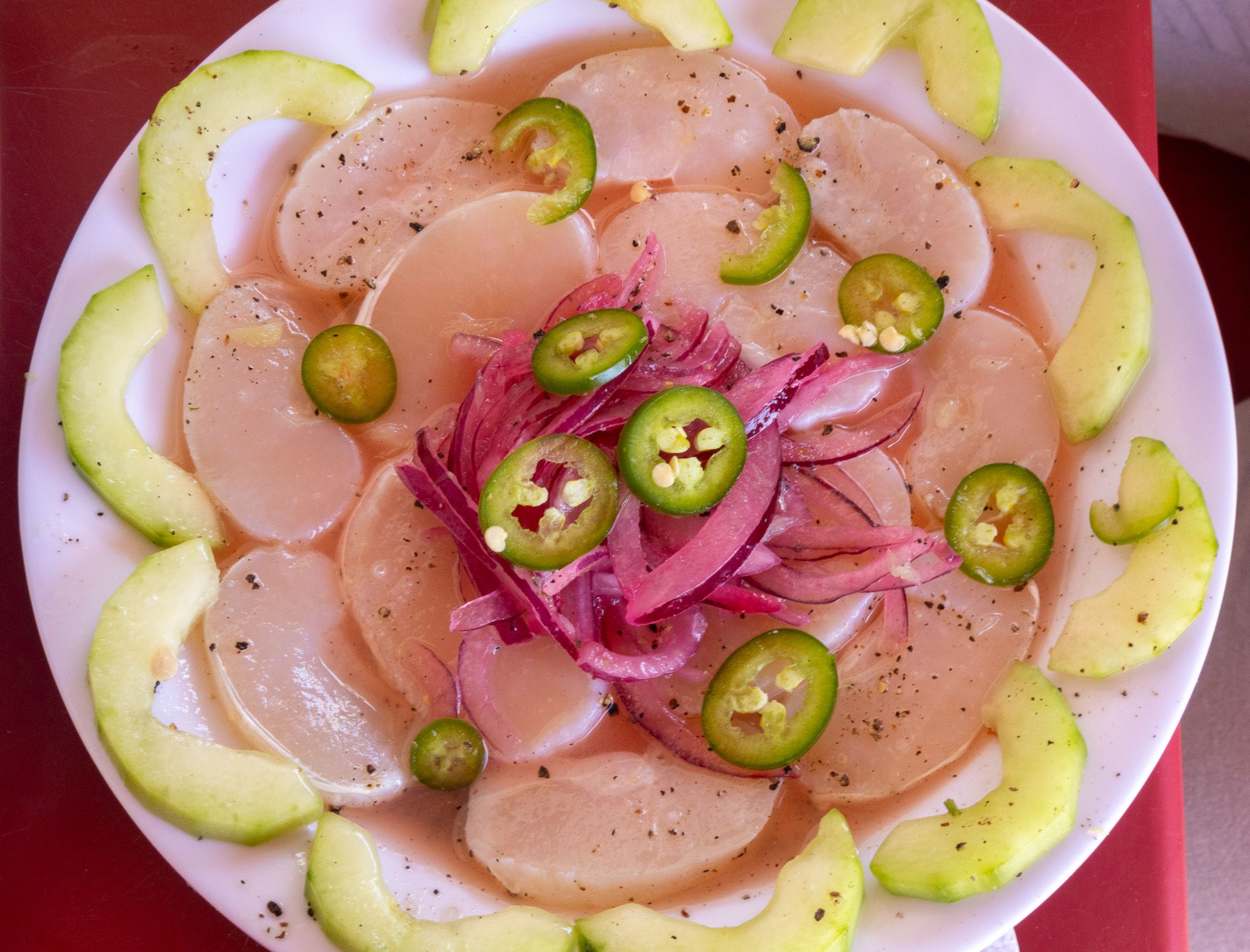Fresh scallop with cucumber, red onion, and green chile.