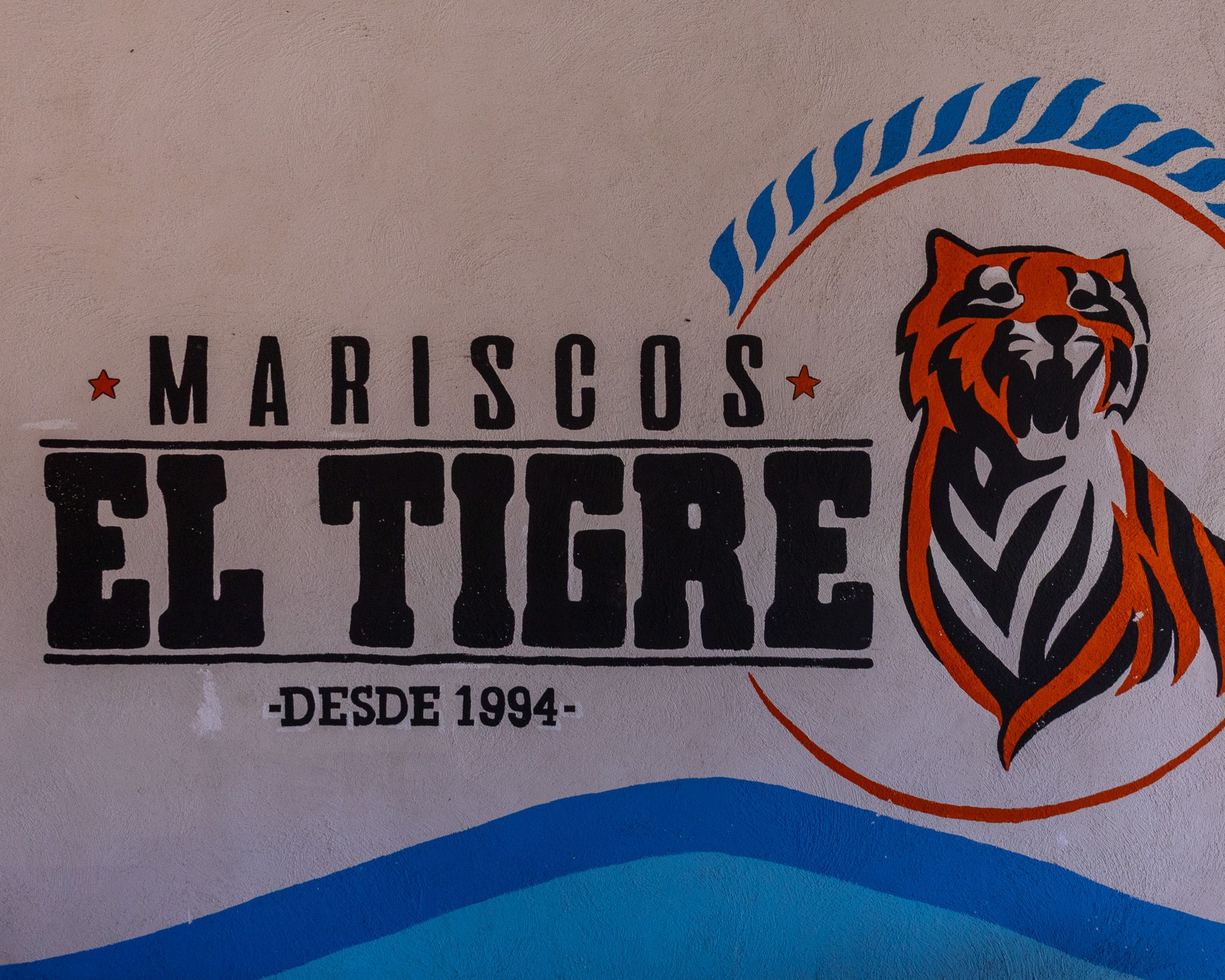 Mural featuring the Mariscos El Tigre name and tiger logo.