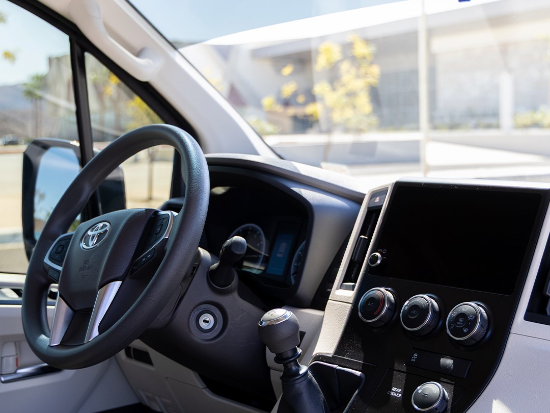 Clean interior and driver controls of the Baja King van